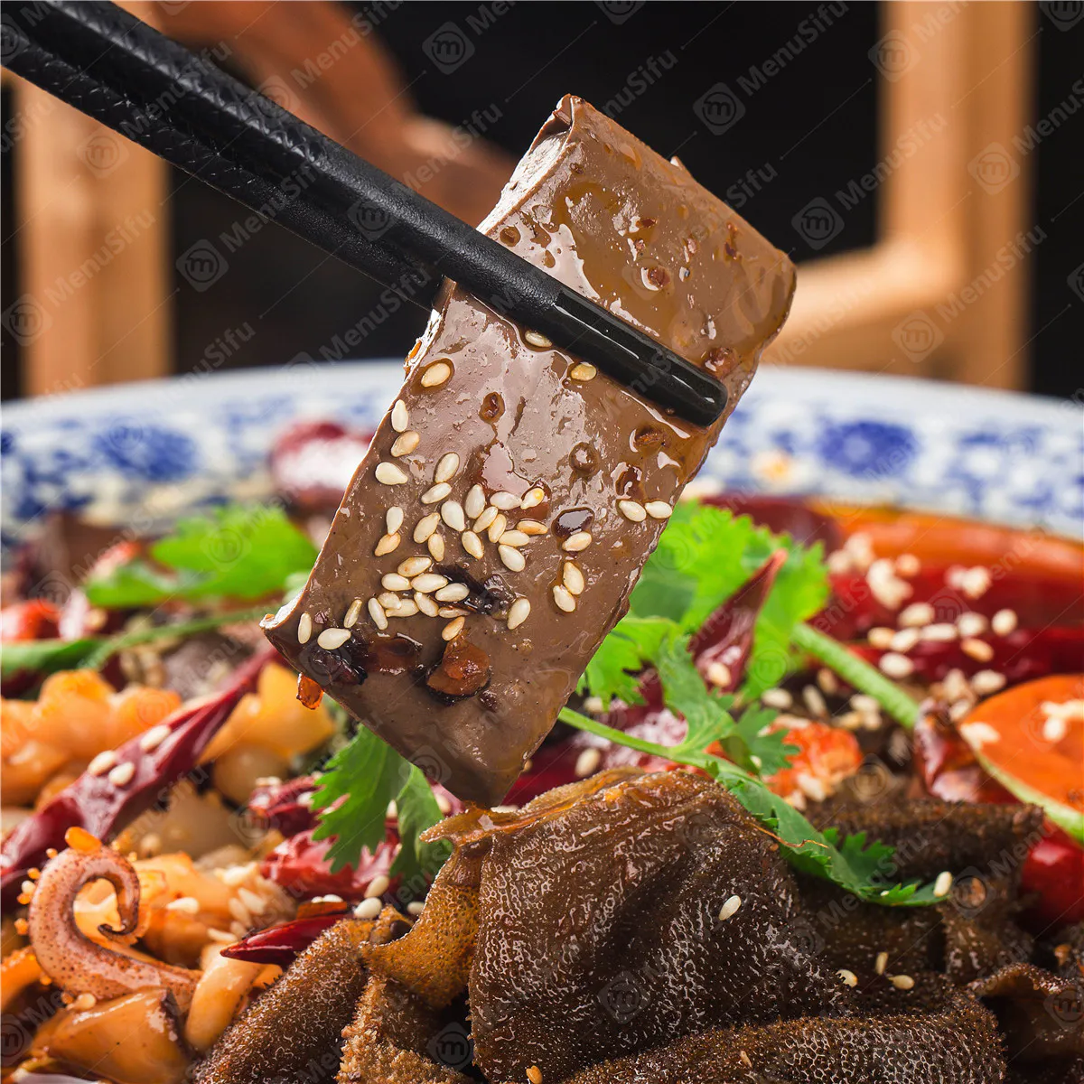 Maoxuewang spicy blood tofu tripe dish lifted with black chopsticks at Sichuan Wok, a Chinese Restaurant in Troy
